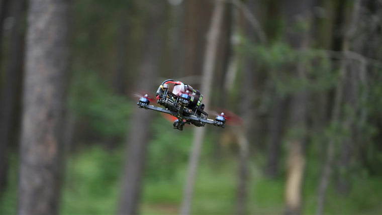 FPV racing drone flying through a forest